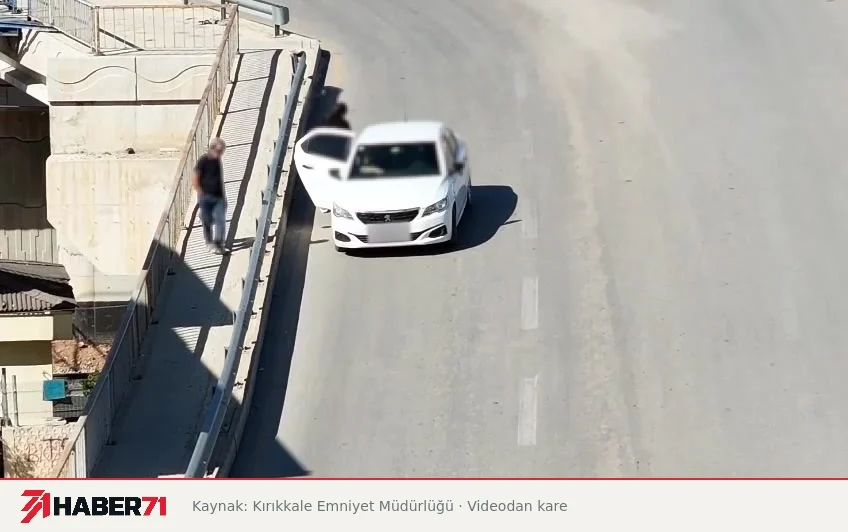 Habere ilişkin paylaşılan görüntüler Ahıllı Kavşağı’nda yol kenarında duran beyaz otomobil ve açık kapısının yanındaki kişi; drone videosundan kare.