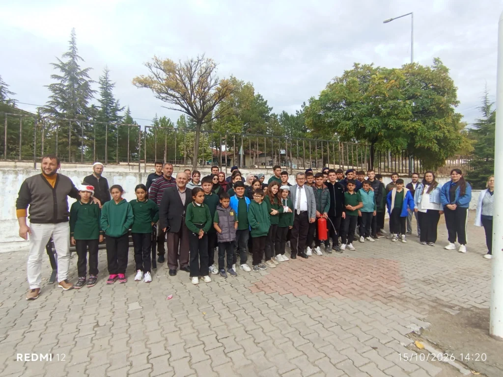 Afet eğitimi ve tatbikat katılımcıları okul bahçesinde bir araya geldi.
Öğrenciler, eğitimciler ve destek ekipleri okul bahçesinde toplu fotoğraf çekiliyor.