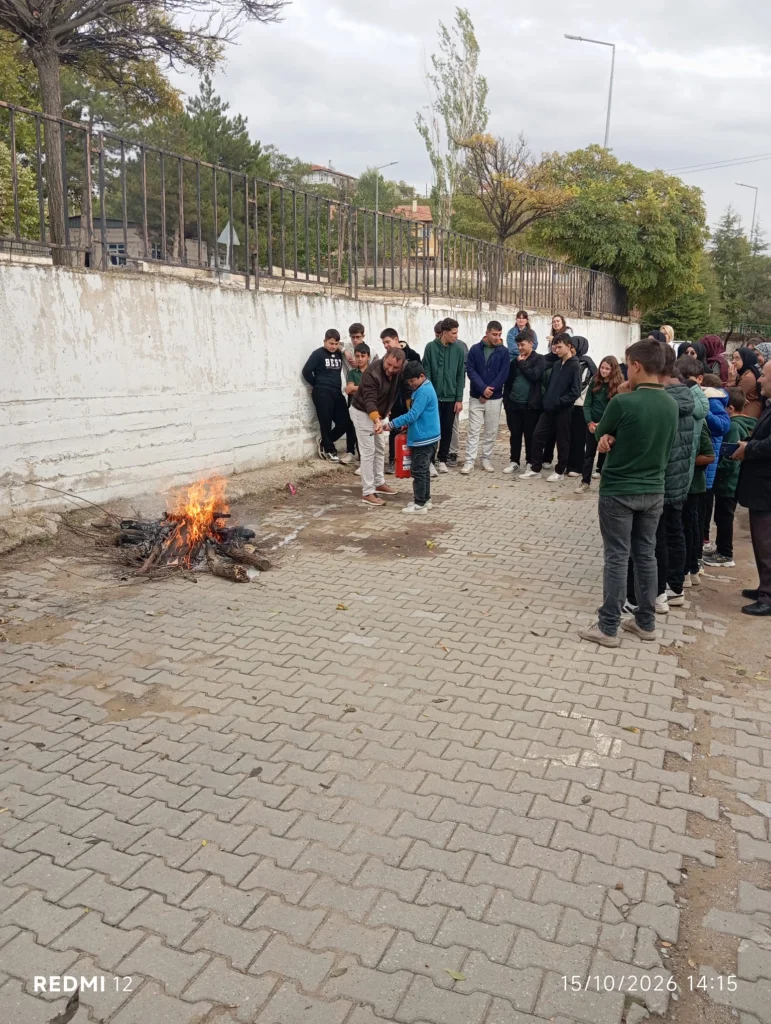 Yangına müdahale uygulamalı olarak anlatıldı.
Okul bahçesinde öğrenciler gözetiminde yangın söndürme uygulaması yapılıyor.