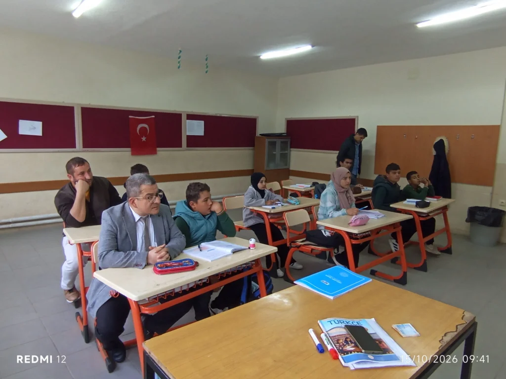 Okuldaki afet farkındalığı çalışmasından bir görünüm.
Eğitimci ve öğrenciler sınıfta birlikte oturarak dersi takip ediyor.