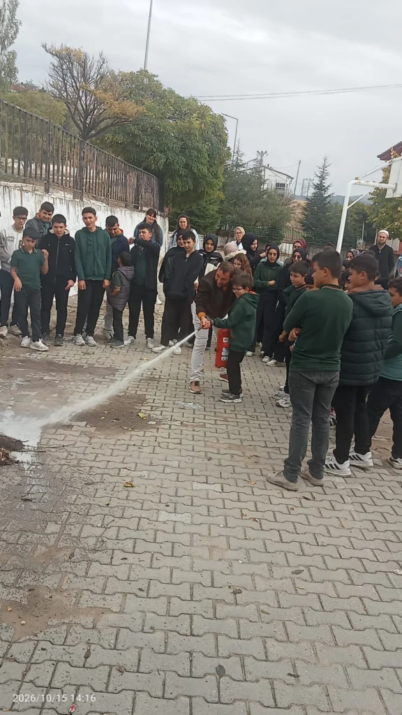 Yangın söndürme cihazının kullanımı tatbikatta gösterildi.
Gözetim altındaki öğrenci okul bahçesinde yangın söndürme cihazıyla uygulama yapıyor.