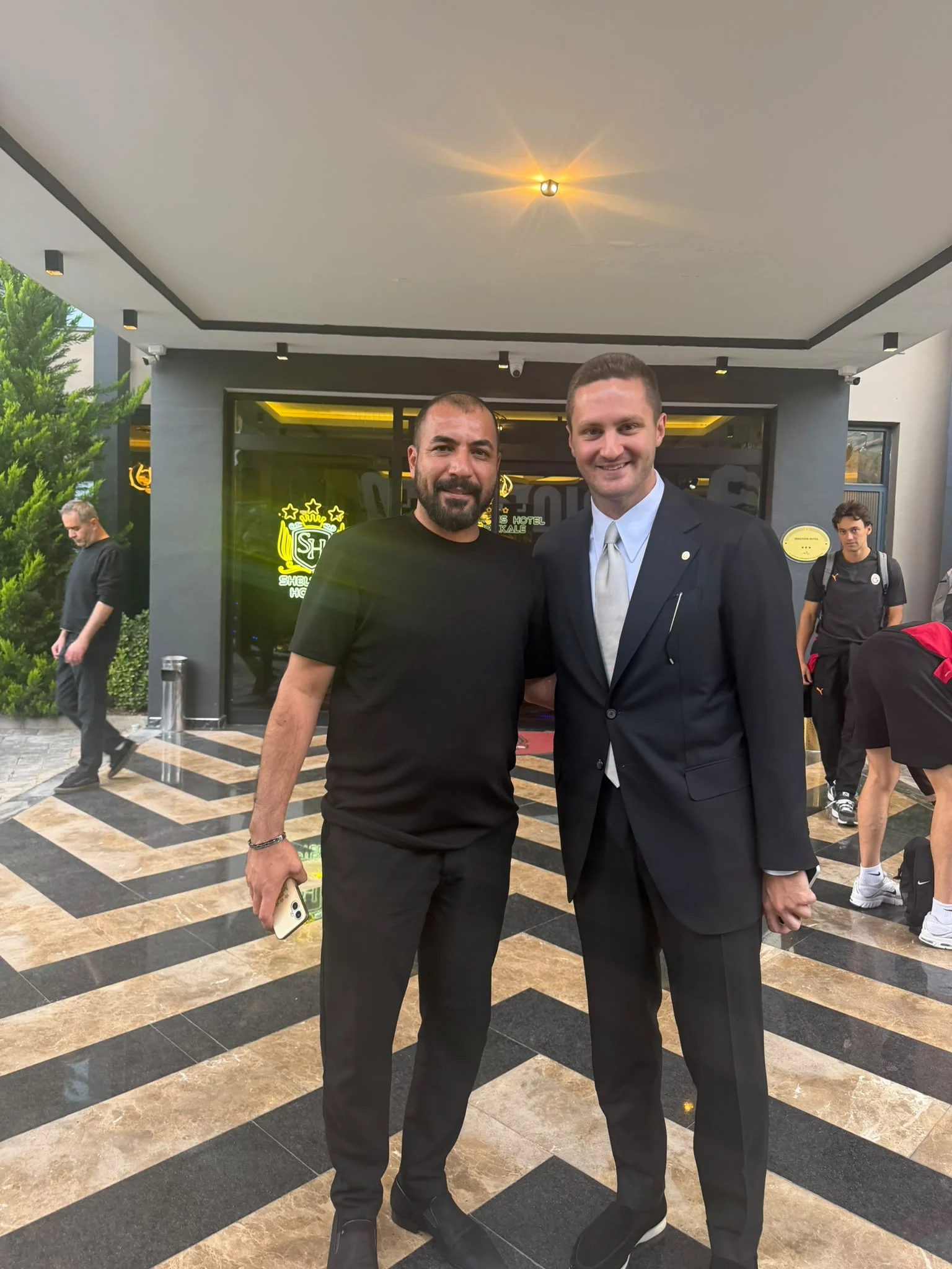 Sheltons Hotel girişinden iletilen fotoğraf. Sheltons Hotel girişinde yan yana duran iki kişi