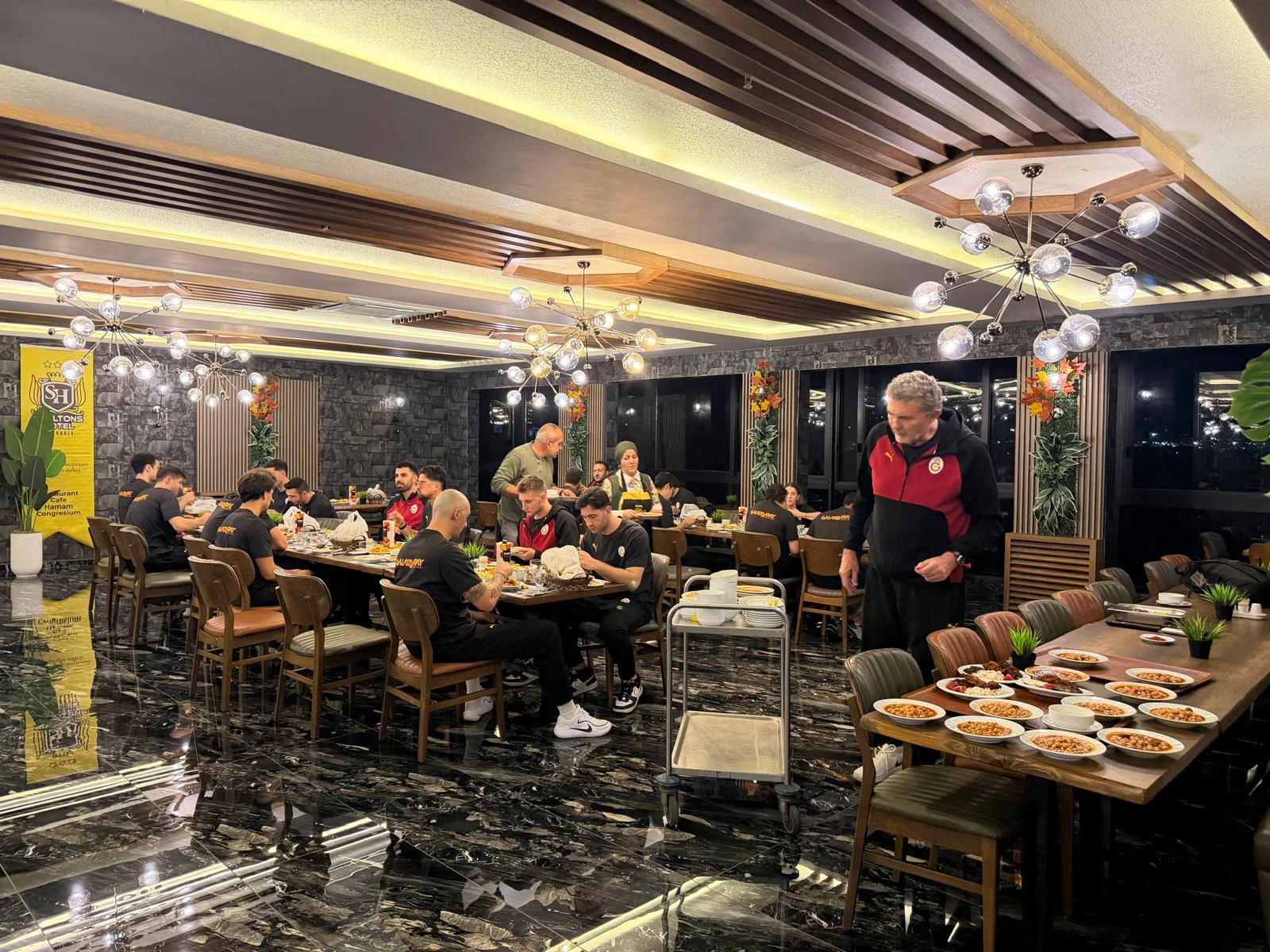 Otelin yemek alanından iletilen görüntü. Sheltons Hotel yemek alanında masalarda oturan grup