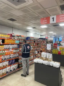 Migros mağazasında ürünlerin fiyat etiketlerini kontrol eden görevli Migros mağazasında ürünlerin fiyat etiketlerini kontrol eden görevli