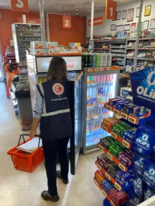 Migros mağazasında içeceklerin fiyat etiketlerini kontrol eden görevli Migros mağazasında içeceklerin fiyat etiketlerini kontrol eden görevli