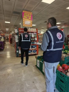 Migros mağazasında ürün reyonlarını inceleyen görevliler Migros mağazasında ürün reyonlarını inceleyen görevliler