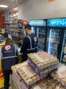 Migros mağazasında denetim kayıtlarını inceleyen görevliler Migros mağazasında denetim kayıtlarını inceleyen görevliler